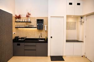 a kitchen with white cabinets and a sink at Dreamview Mountains - Cozy 1bhk with Sunrise view in Karjat