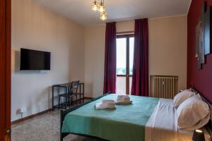 a bedroom with a bed with two towels on it at Il Grappolo d'Oro Family - Appartamento in centro in Tortona