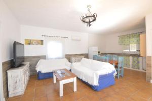 a living room with two beds and a table at Casa Samuel con piscina comunitaria y porche in Cádiz