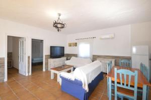 a living room with a blue couch and a table at Casa Samuel con piscina comunitaria y porche in Cádiz