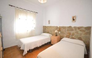 a room with two beds and a window in it at Casa Samuel con piscina comunitaria y porche in Cádiz