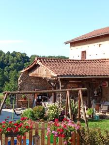 a house with a fence and flowers in front of it at Chambres D'hôtes Les Noisetiers in Saint-Martin-Lestra