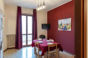 a dining room with a table with a red wall at Il Grappolo d'Oro Family - Appartamento in centro in Tortona