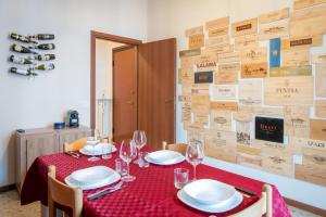 a table with plates and wine glasses on it at Il Grappolo d'Oro Family - Appartamento in centro in Tortona +10 photos