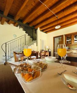 a table with glasses of orange juice and a bowl of fruit at Ca Malfer in Costermano sul garda
