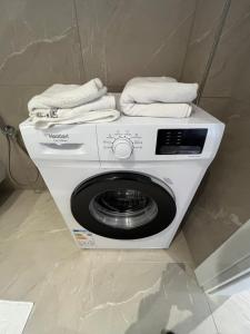 a white washing machine with towels on top of it at Ciel Apartement in Orikum