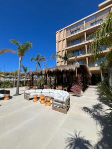 a hotel patio with couches and tables and palm trees at Ciel Apartement in Orikum