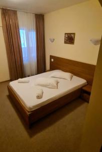 a large bed in a room with a window at Motel Casa Stimatu in Bărcăneşti