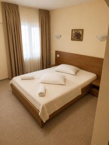 a bedroom with a large bed with white sheets at Motel Casa Stimatu in Bărcăneşti
