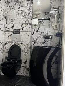 a bathroom with a black toilet and a marble wall at AsiaHOTEL in Bodrum City +14 photos