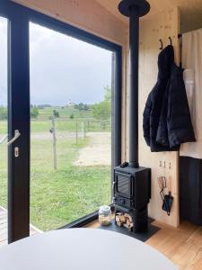 a stove in a room with a view of a field at Cabin stay with optional Donkey Picnic Experience in Hallau