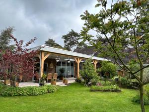 a house with a yard with grass and trees at Bed&Breakfast Kamersven in Maarheeze