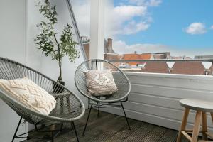 a balcony with two chairs and a window at Haarlem Hotel Suites in Haarlem