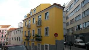 リスボンにあるLisbon Sloped Ceiling Apartmentの通路脇の黄色い建物