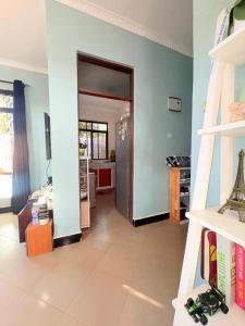 a living room with blue walls and a hallway at Maliasili Apartments in Mwanza