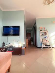 a living room with a flat screen tv on the wall at Maliasili Apartments in Mwanza