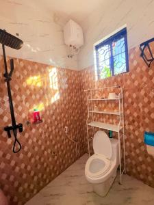 a bathroom with a toilet and a window at Maliasili Apartments in Mwanza