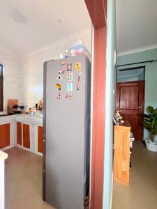 a refrigerator in a kitchen with magnets on it at Maliasili Apartments in Mwanza +4 photos