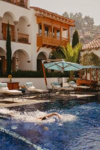 a person swimming in a pool in a hotel at Palacio Nazarenas, A Belmond Hotel, Cusco in Cusco