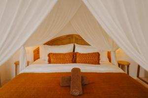 a bedroom with a bed with a large white canopy at Luana Lombok in Selong Belanak