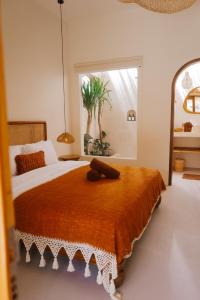 a bedroom with a large bed with a large window at Luana Lombok in Selong Belanak