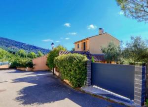 a house with a fence in front of a driveway at La Maison Bleue in Rustrel