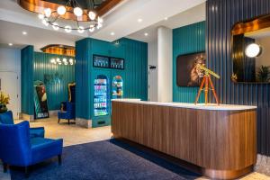 a lobby with a reception desk and blue chairs at Hotel Royal William, an Ascend Collection Hotel in Quebec City