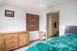 a bedroom with a green bed and a wooden dresser at Ferienwohnung Schrödter in Schramberg