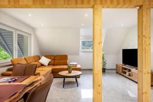 a living room with a couch and a tv at Ferienwohnung Schrödter in Schramberg