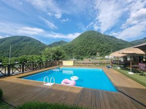 a large swimming pool with mountains in the background at Danyang Kotdle Moolgam Chatki Pension in Danyang