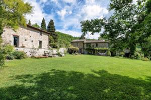 a large yard with a house and a tree at Assisi Countryhouse in Assisi