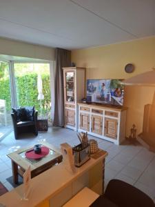 a living room with a table and a tv at Huus Kompass - Familienurlaub mit Hund nahe am Nordseestrand in Butjadingen