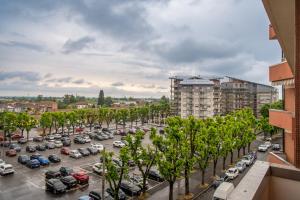 a parking lot with cars and trees in a city at Il Grappolo d'Oro Family - Appartamento in centro in Tortona