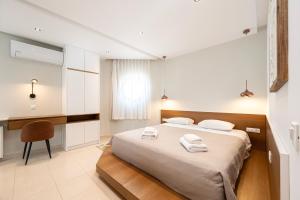 a bedroom with a bed with two towels on it at The Infinities - Premium Villa Alexandros in Kos