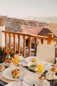 a table with plates of food on a balcony at Palacio Nazarenas, A Belmond Hotel, Cusco in Cusco