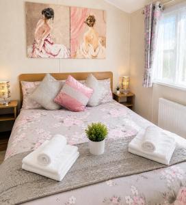a bedroom with a bed with towels on it at Magic Caravan Camber Sands 221 in Camber