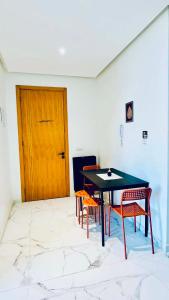 a room with a table and chairs and a wooden door at Prestige Stay a Perla Méditerranée avec Picine au Centre Mdiq in M'diq