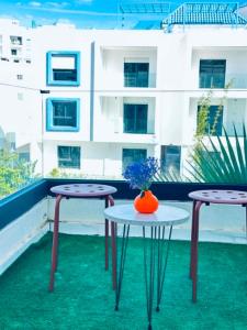 two tables and a vase on top of a roof at Prestige Stay a Perla Méditerranée avec Picine au Centre Mdiq in M'diq