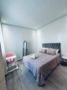 a bedroom with a large bed and a chair at Prestige Stay a Perla Méditerranée avec Picine au Centre Mdiq in M'diq +32 photos