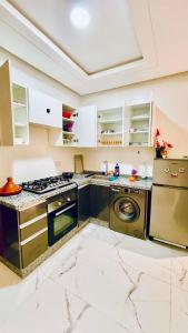 a kitchen with a stove and a dishwasher at Prestige Stay a Perla Méditerranée avec Picine au Centre Mdiq in M'diq