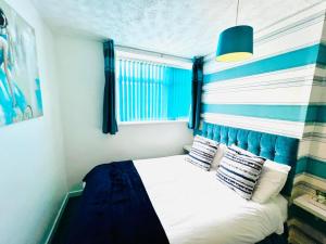 ein kleines Schlafzimmer mit einem blau-weiß gestreiften Bett in der Unterkunft Beeches Hotel in Blackpool