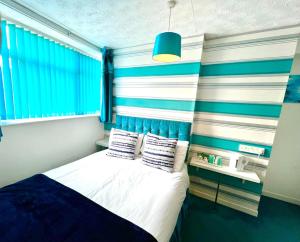ein Schlafzimmer mit einem Bett mit blau-weißen Streifen in der Unterkunft Beeches Hotel in Blackpool + 18 Fotos