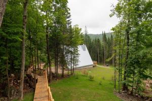 a house with a white roof in the woods at Canadian Classic - Spa - Sauna - Fire - Forest in Val-David