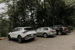 a group of three cars parked in a parking lot at Canadian Classic - Spa - Sauna - Fire - Forest in Val-David