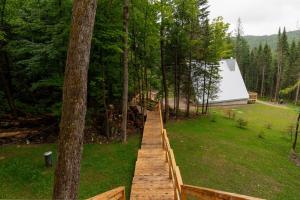 a wooden boardwalk leading to a cabin in the woods at Canadian Classic - Spa - Sauna - Fire - Forest in Val-David