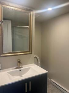 a bathroom with a sink and a mirror at ocean view two bedroom suite in Oak Bay +5 photos