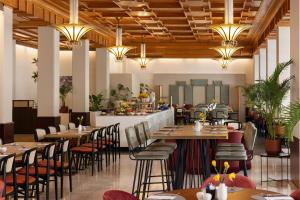 ein Restaurant mit Holzdecken, Tischen und Stühlen in der Unterkunft NH Atlanta Rotterdam Hotel in Rotterdam + 40 Fotos