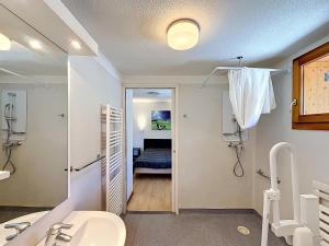 a bathroom with a sink and a room with a bed at L'Eterlou by Mountain Collection Immobilier in Saint-Chaffrey +117 photos