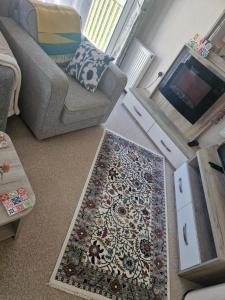 ein Wohnzimmer mit Sofa und Teppich in der Unterkunft Maise's in Camber
