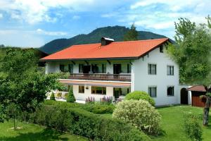 a large white house with an orange roof at Ferienwohnung Weiß inkl. Chiemgaukarte in Ruhpolding